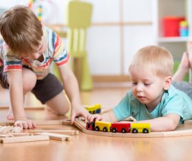 Two little boys playing with toy train Stock Photo