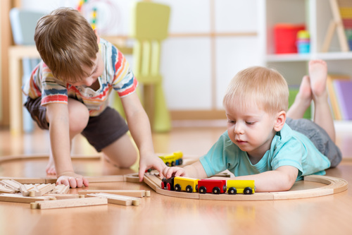 Two little boys playing with toy train Stock Photo
