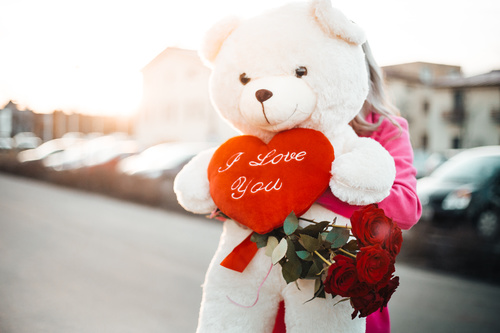 Woman Holding a Big Teddy Bear with I Love You Heart Stock Photo