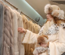Woman buys choice of mink coat Stock Photo
