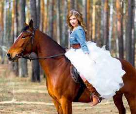 Woman riding brown horse Stock Photo