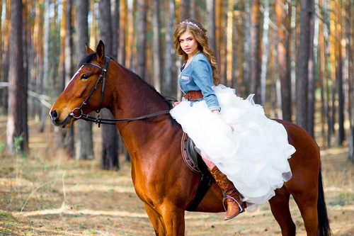 Woman riding brown horse Stock Photo