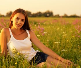 Woman sitting on the grass in the wild Stock Photo