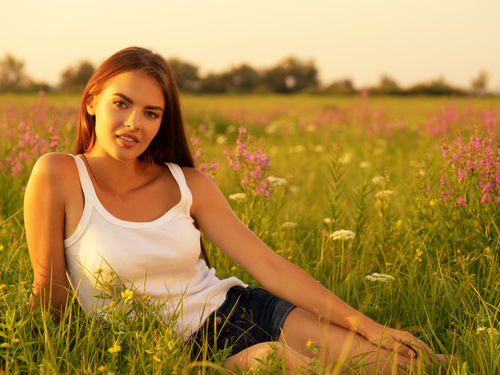 Woman sitting on the grass in the wild Stock Photo