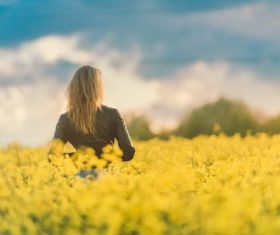Woman standing in meadow of yellow flowers Stock Photo