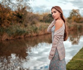 Woman standing tattooed by the river looking away Stock Photo