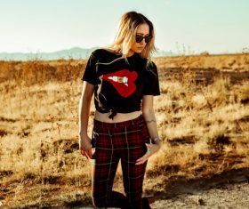 Woman wearing black t-shirt plaid pants posing Stock Photo