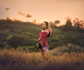 Woman wearing red dress arms up outdoors Stock Photo