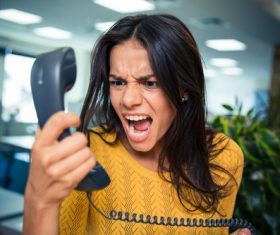 Angry woman holding telephone receiver Stock Photo