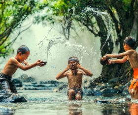 Children in the river splash each other Stock Photo