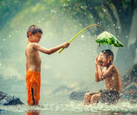 Children playing in the river with lotus leaves Stock Photo 02