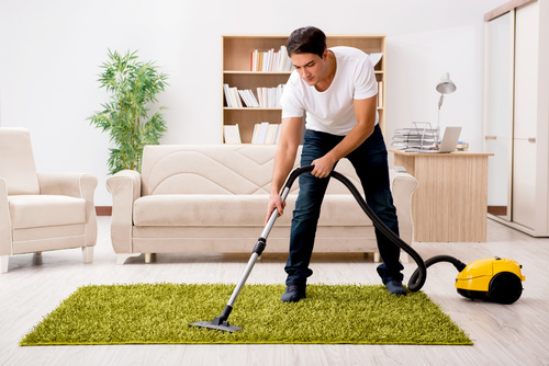 Cleaning the living room with vacuum cleaner Stock Photo