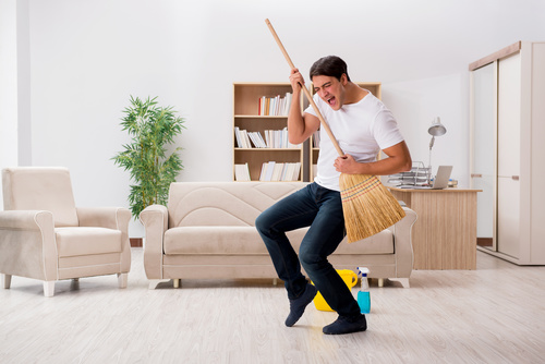 Funny man holding a broom Stock Photo