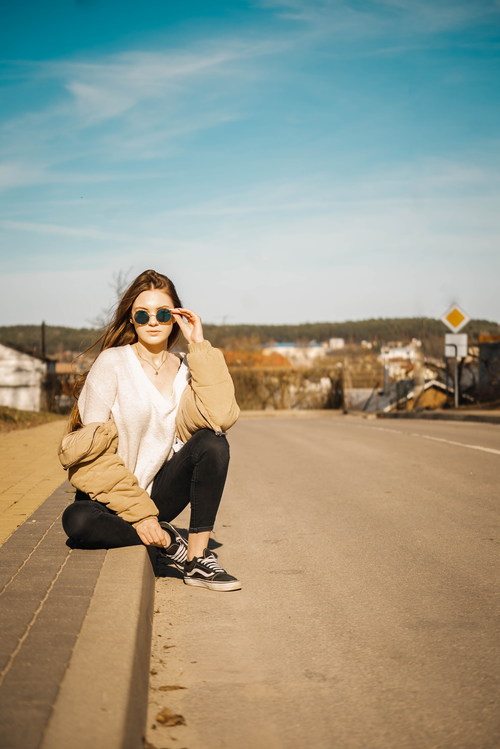 Hand support sunglasses woman sitting on the roadside Stock Photo