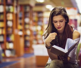 Long hair girl reading book in the library Stock Photo