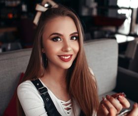 Smiling woman holding lipstick in hand Stock Photo