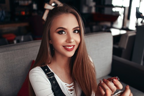 Smiling woman holding lipstick in hand Stock Photo