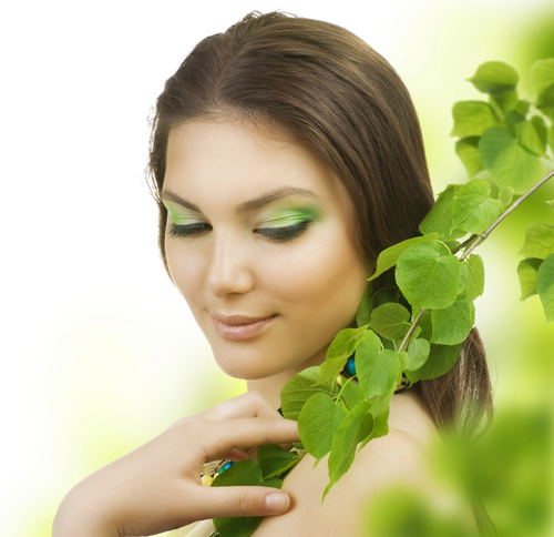 Woman green eyeshadow and green branches Stock Photo