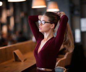 Woman in glasses holds hair in hand Stock Photo