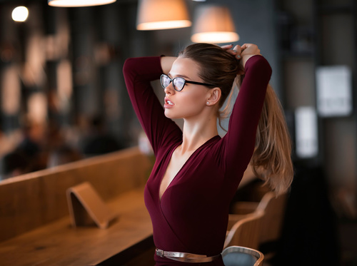 Woman in glasses holds hair in hand Stock Photo