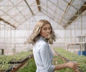 Woman in the greenhouse turned and looked Stock Photo