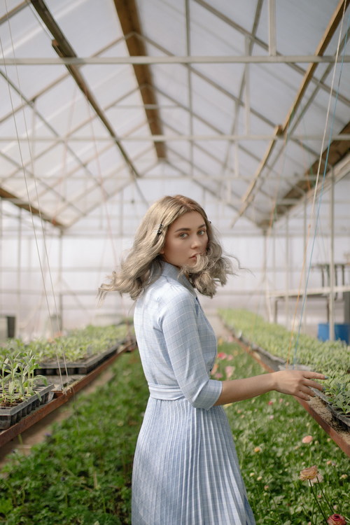 Woman in the greenhouse turned and looked Stock Photo