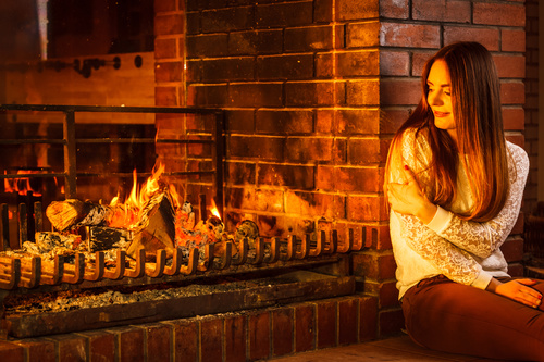 Woman relaxing at fireplace Stock Photo 01