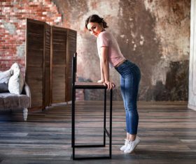 Woman standing on tiptoe indoors Stock Photo