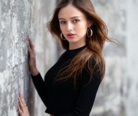 Woman wearing black sweater wearing hoop earrings Stock Photo